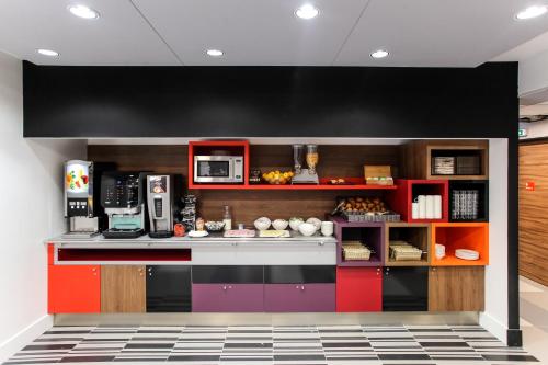 a kitchen with red and purple cabinets at Hotel Reseda in Bagnolet
