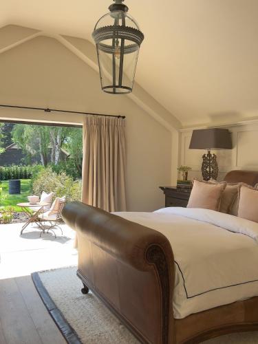 a bedroom with a bed and a large window at Surrey Barn, Newly Renovated in Ripley