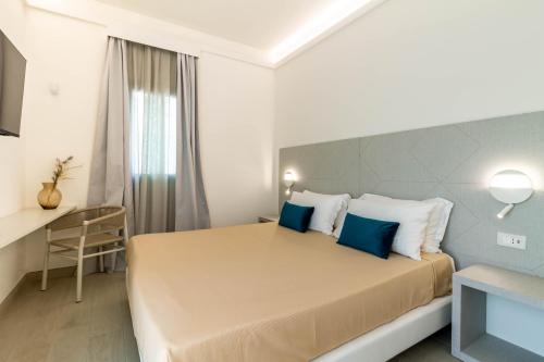 a bedroom with a large bed with blue pillows at Affittacamere Mare Poetto Cagliari in Quartu Sant'Elena
