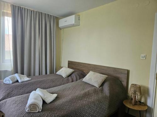 a hotel room with two beds with towels on them at Вила Магнолия in Lakarevo