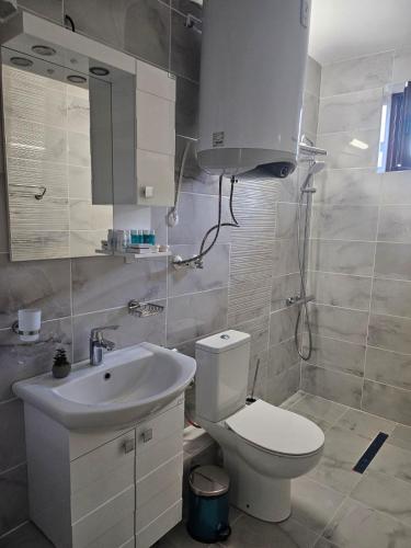 a bathroom with a white toilet and a sink at Вила Магнолия in Lakarevo