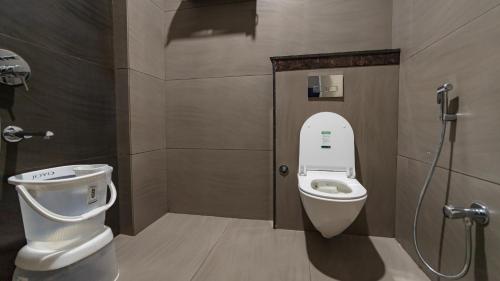 a bathroom with a toilet and a shower stall at Hotel Pinaki Inn in Ujjain