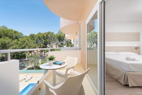 a balcony with a bed and a table and chairs at Welikehotel Fenix in El Arenal