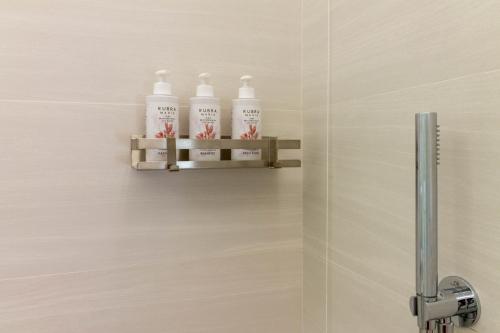 four bottles of bleach on a shelf in a bathroom at Affittacamere Mare Poetto Cagliari in Quartu Sant'Elena