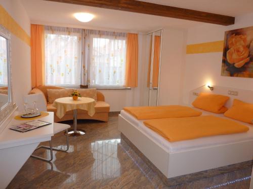 a bedroom with a bed and a living room at Hotel und Pension Am Burchardikloster in Halberstadt