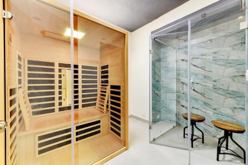 a glass walk in closet with a table and stool at Indo Asia Heritage Coorg, formerly Heritage Resort Coorg in Madikeri