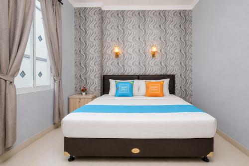 a bedroom with a bed with colorful pillows on it at Sans Vibes Flamenco Hotel in Jakarta
