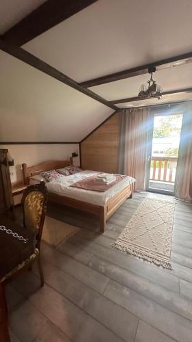 a bedroom with a bed and a large window at Cabana Pârâul Lupilor in Răchitiş