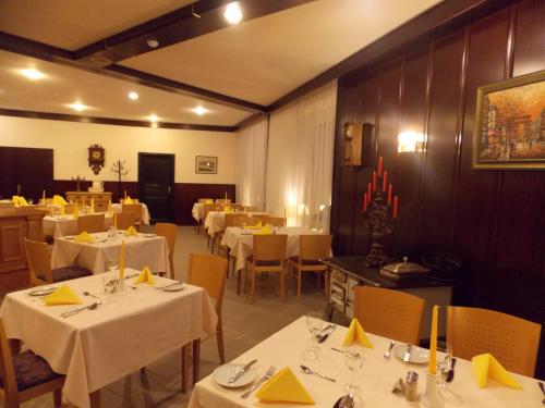 a restaurant with white tables and chairs with yellow napkins at Hotel Krone in Bad Münster am Stein-Ebernburg