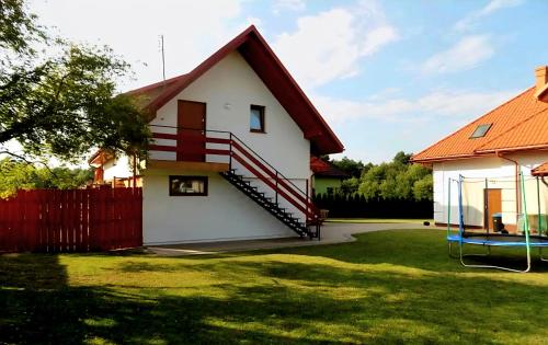 a house with a red roof and a yard at Zacisze in Józefów