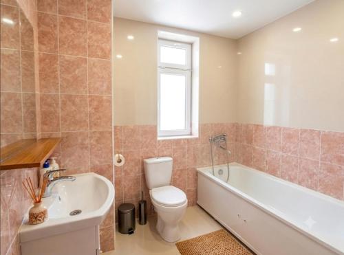 a bathroom with a toilet and a tub and a sink at BoNa Guest in Bishkek