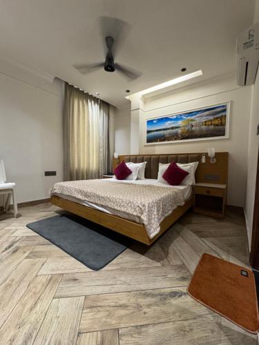 a bedroom with a large bed with red pillows at HOTEL ELiTE in Pānīpat