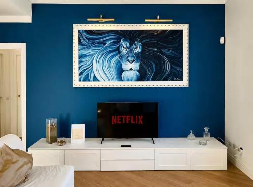 a living room with a tv and a blue wall at La Casa Del Pittore - Centro Storico in Legnano