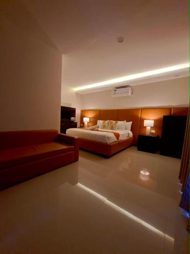 a hotel room with a bed and a couch at Oceanaire Beach Resort ELYU in Bacnotan