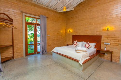 a bedroom with a bed in a brick wall at Legato House in Talpe