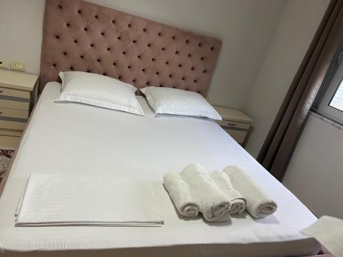a bed with two towels and two pillows on it at Sunshine Apartment in Sarandë