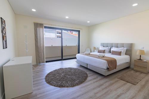 a bedroom with a large bed and a large window at Apartamento Cabine by Algarve Holidays in Quarteira
