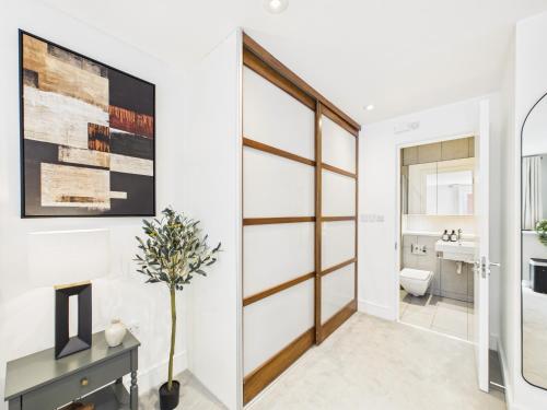 a bathroom with white walls and a sliding door at Westminster Residences by Apt in London