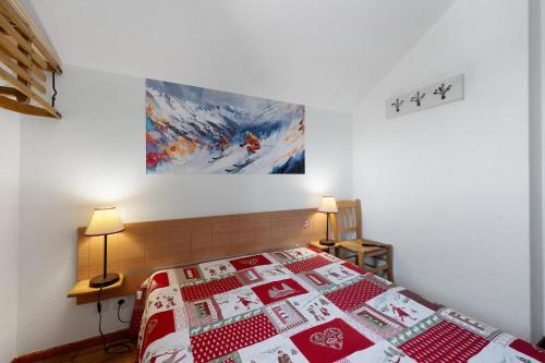 a bedroom with a bed with a red and white quilt at Valmeinier le Miras in Valmeinier