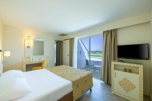 a hotel room with a bed and a balcony at Crystal Admiral Aqua Collection - Ultimate All Inclusive in Kızılot