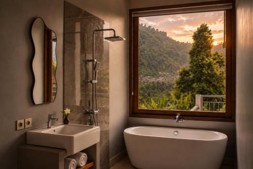 a bathroom with a tub and a sink and a window at SARALA sidemen guest house in Sidemen