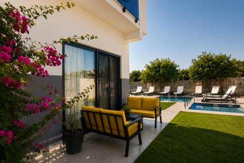 a patio with yellow chairs and a swimming pool at Side Mira Palace & Spa in Side