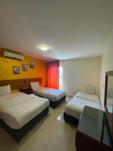 a hotel room with two beds and a window at Zaina Plaza Hotel in Amman