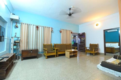 una sala de estar con un sofá y sillas en Silver Sands Malpe Beach Villa, en Udupi