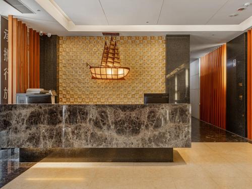 a lobby with a marble counter and aendant light at Guide Hotel Taipei Chongqing in Taipei