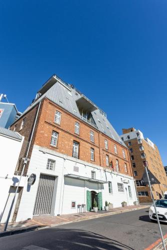a large white building on the side of a street at ONOMO Hotel Waterfront in Cape Town
