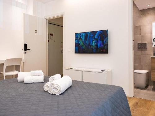 a bedroom with a bed with towels on it at ABBA ROOMS in Cagliari
