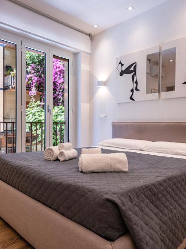 a bedroom with a large bed with two towels on it at ABBA ROOMS in Cagliari