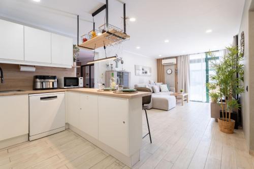 a kitchen with white cabinets and a living room at Paz Ocean View Luxury, 2 Air conditioners, Fast Wifi, Heated pool in San Miguel de Abona