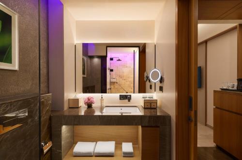 a bathroom with a sink and a large mirror at Vivanta Gurugram Sector 95A in Gurgaon