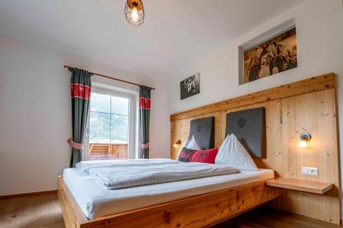 a bedroom with a bed with a wooden headboard at Untersillerhof in Neustift im Stubaital