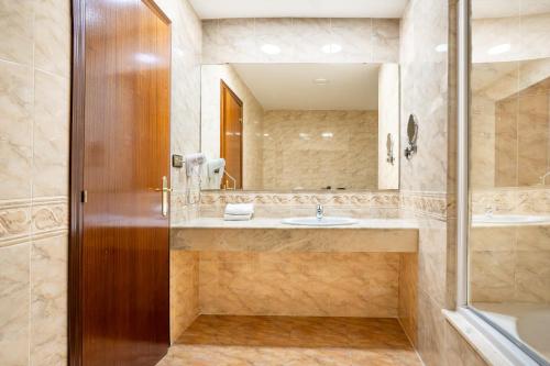 ein Badezimmer mit Waschbecken und Spiegel in der Unterkunft Checkin Valencia Ciscar in Picanya