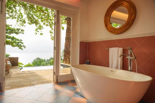 a bathroom with a tub and a large window at Belo Monte - Principe Collection in Santo António