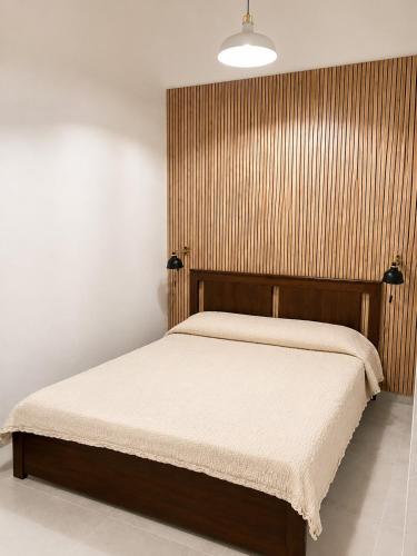 a bedroom with a bed with a wooden headboard at Valledoria Central Modern Studio in Valledoria