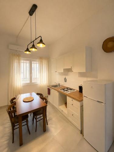 a kitchen with a table and a white refrigerator at Valledoria Central Modern Studio in Valledoria