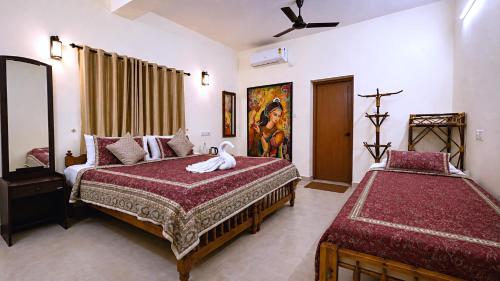 a bedroom with two beds and a bird on the bed at Aryavilla Heritage in Varkala