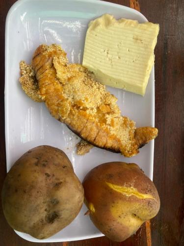 a plate of food with meat and potatoes and butter at La Bahia de Makale in Pisco