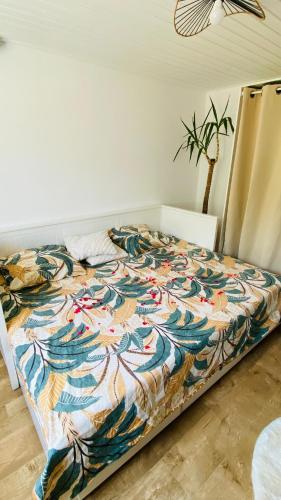 a bed with a colorful quilt on it in a room at Studio Saint Julien de Concelles 5 minutes de la Loire in Saint-Julien-de-Concelles