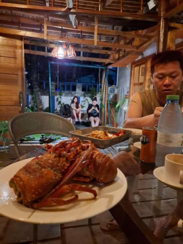 a man sitting at a table with a plate of food at The Blue Cave Maldives in Kendhoo