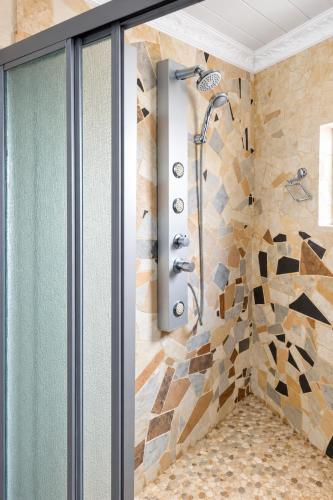a shower in a bathroom with a stone wall at Nairobi Guesthouse in Orkney
