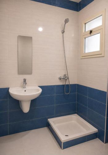 a blue and white bathroom with a sink and a shower at dalina resort in El Alamein