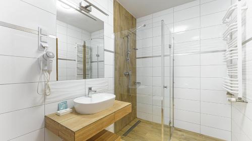 a white bathroom with a sink and a shower at PAN Dom Pracy Twórczej w Wierzbie in Wierzba