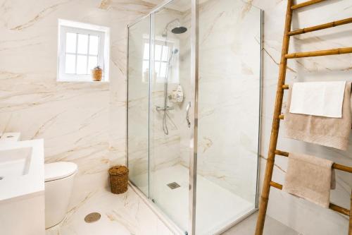 a shower with a glass door in a bathroom at Villa Rafa in Costa Nova