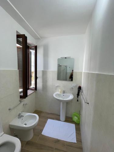 een witte badkamer met een wastafel en een toilet bij Dimora AVE in Aieta