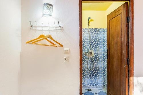 a bathroom with a shower and a hanger next to a door at Gîte Imsker Elbour in Asni