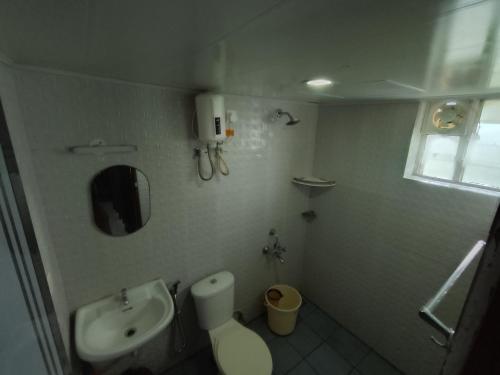 a small bathroom with a toilet and a sink at Hovato Brown in Nedumbassery